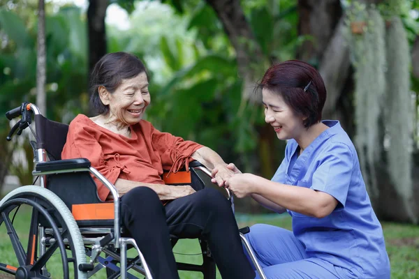 Felicidade da mulher idosa conversando com cuidador — Fotografia de Stock