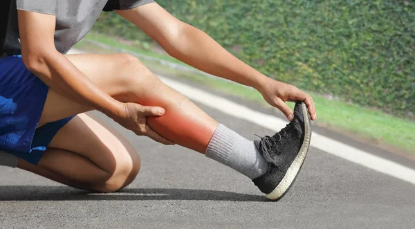 Manliga medelålders har en kramp medan jogging. Stoppa och massera — Stockfoto