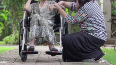 Kızı evde tekerlekli sandalyede yaşlı anne bakmak