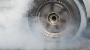 Yarış pistinde kalkış çizgisinde yarış arabasının lastiği yanıyor.