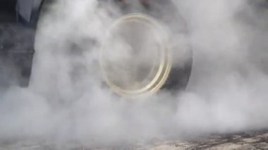 Yarış pistinde kalkış çizgisinde yarış arabasının lastiği yanıyor.