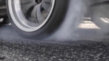 Yarış pistinde kalkış çizgisinde yarış arabasının lastiği yanıyor.