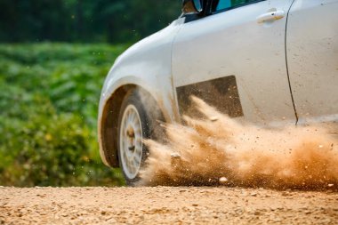 Toprak yolda sürüklenen yarış arabası..