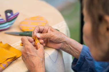 İğne ustası yaşlı bir kadın Alzheimer ya da bunama için meslek terapisi yapıyor.