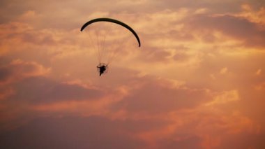 Gün batımı arkaplanındaki siluet paraglider