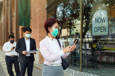 Reopened businesses after covid-19 lockdown , people wearing mask and keep social distancing to avoid the spread of virus clipart