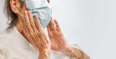 Coronavirus covid-19 'dan korumak için maske takan yaşlı bir kadın.