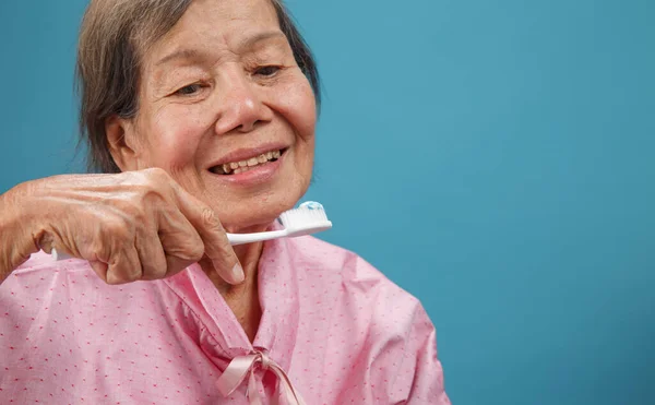 亚洲老年妇女使用牙刷 — 图库照片