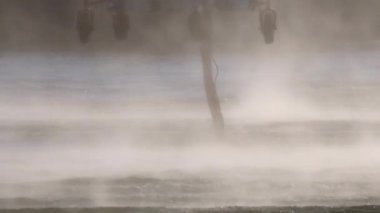 İtfaiye helikopteri su doldurmak için göletin üzerinde uçuyor.