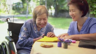 İğne ustası yaşlı bir kadın Alzheimer ya da bunama için meslek terapisi yapıyor.