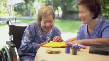 İğne ustası yaşlı bir kadın Alzheimer ya da bunama için meslek terapisi yapıyor.