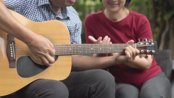Orta Yaşlı Çift Gitar Çalarken Rahatça Arka Bahçede Bankta Oturuyorlar — Stok video