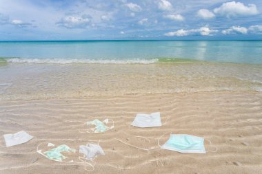 Plajda kullanılmış tıbbi maskelerden kalma çöpler..