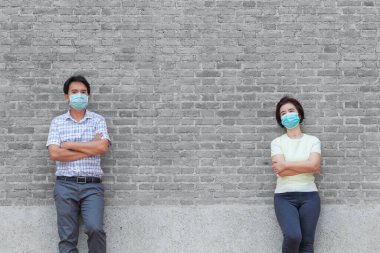 Maske takan Asyalı orta yaşlı insanlar COVID-19 'un yayılmasını önlemek için sosyal mesafeyi koruyorlar.