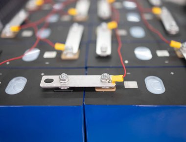 Teknisyen, güneş sistemi dışı sistem için LifePO4 bataryalarını bağlıyor.