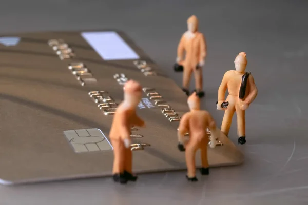Mini workers repair one golden credit card