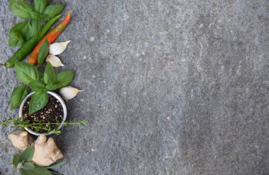 Verschiedene Kraeuter ve Gewuerze auf einer Granitsteinplatte