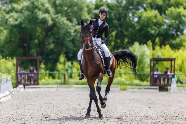 Jeune femme à cheval sur dressage test avancé — Photo