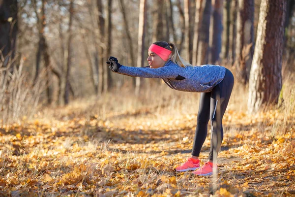 Young fitness woman stretching body before jogging — Stock Photo, Image