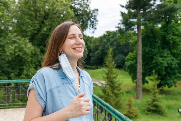 Young woman feels happy and breathes fully after put off medical mask — Stock Photo, Image