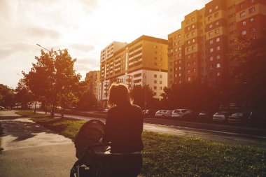 Annesi şehirde bebek arabasıyla geziyor.