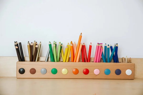 Lápices de colores en un recipiente sobre una mesa de madera — Foto de Stock