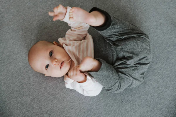 Neugeborenes Stretching von Armen und Beinen auf dem Boden, Draufsicht — Stockfoto