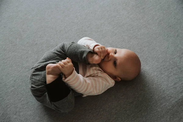 Neugeborenes Stretching von Armen und Beinen auf dem Boden, Draufsicht — Stockfoto