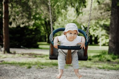 Küçük çocuk salıncakta eğleniyor.