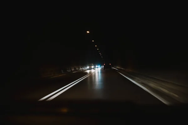 Conduire une voiture à travers un tunnel dans le noir — Photo