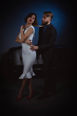 kibirli bir görünüm ile bir kız sadakatle ve itaatkar onu takip eden bir adamın kravat çeker.