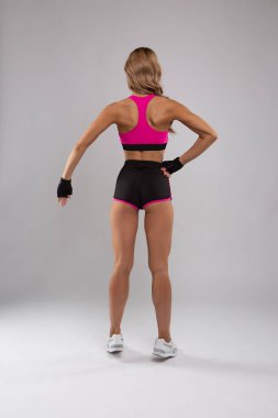 güzel atletik kız arka kasları gösteren kadar kollarını kaldırdı. izole arka plan üzerinde spor iç çamaşırı genç kadın