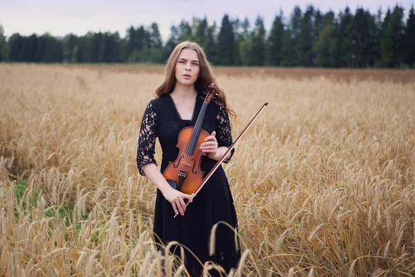 서있는 아름다운 여성이 바이올린을 누릅니다 — 스톡 사진