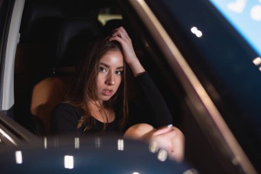 prestijli bir arabanın salonunda kız korkuyla saçlarını düzleştirmek