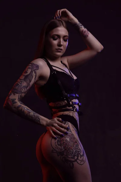 Wspaniała młoda modelka z tatuażem pozuje seksownie na ciemnym, odizolowanym tle — Zdjęcie stockowe