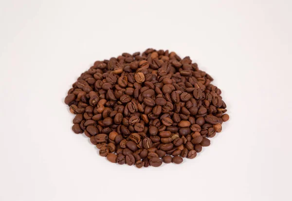 Granos de café tostados en una pila uniforme aislada sobre un fondo blanco . — Foto de Stock