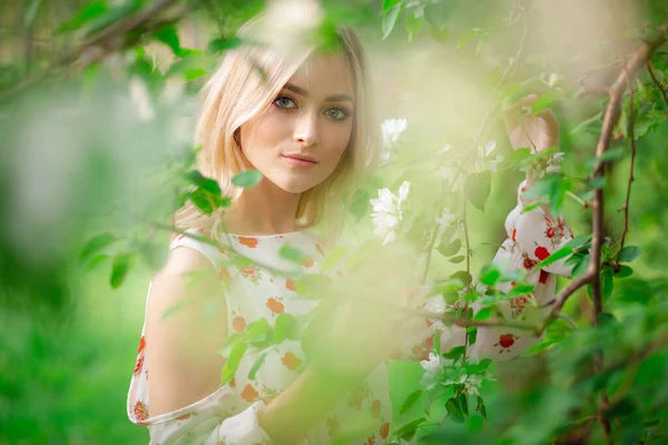 Atraktivní mladá žena s blond vlasy v kvetoucím jablečném sadě — Stock fotografie