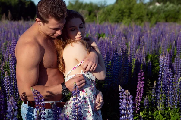 Sexy mujer y hombre en un campo de flores — Foto de Stock