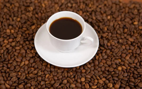 Eine Tasse heißen Kaffee steht auf den Bohnen — Stockfoto