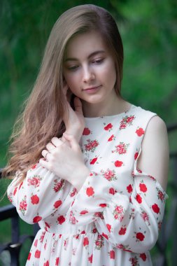 Açık havada romantik bir kız. Havalı kısa bir elbise giymiş güzel genç bir kadın açık havada poz veriyor.