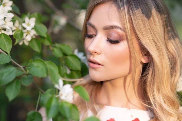 Zblízka portrét sexy blondýny obdivující Apple květy v letní zahradě — Stock fotografie