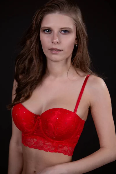 Splendida donna in biancheria intima rossa sexy, su uno sfondo nero isolato — Foto Stock