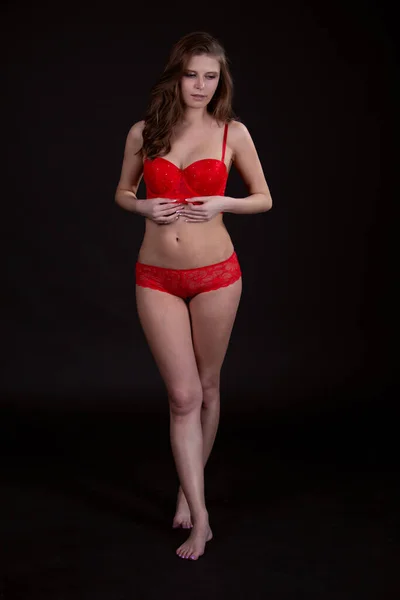 Mujer joven atractiva con una hermosa figura en ropa interior roja —  Fotos de Stock