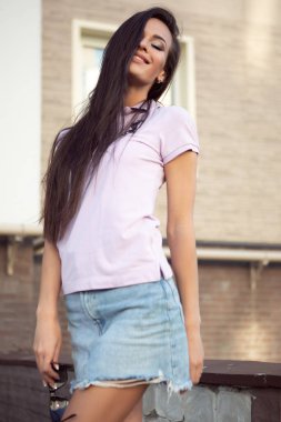 Açık havada poz veren çekici genç esmer kadın..