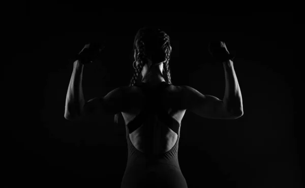 Жестокая атлетичная женщина демонстрирует свои мускулы, поднимая руки.. — стоковое фото