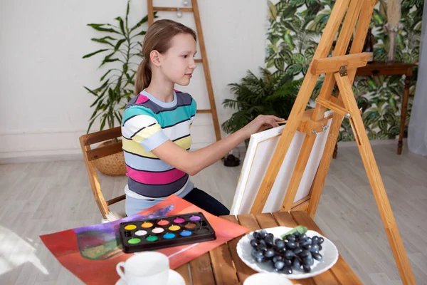 Meisje kunstenaar schetst een beeld op doek met olieverf — Stockfoto