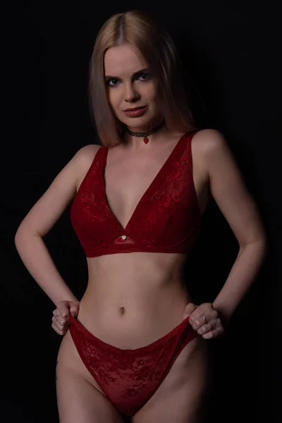 Szexi szőke nő piros alsóneműben húzza fel a bugyiját — Stock Fotó
