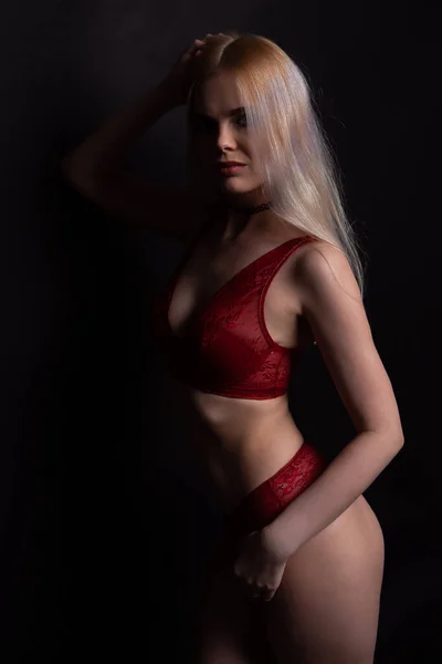 Sexy blonde Frau in roter Lacy-Unterwäsche mit ausdrucksstarkem Look und hinreißender Figur — Stockfoto