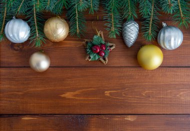 Koyu tahtalarda parlak Noel süslemeleri olan Noel ağacı dalları