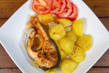 Balık tabağı. Lezzetli ve iştah açıcı alabalık. Patates garnitürlü ve domatesli.